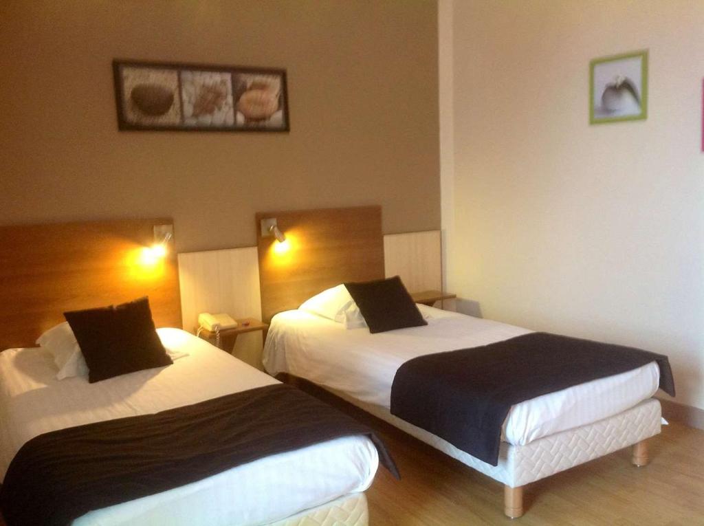 een hotelkamer met 2 bedden in een kamer bij Brit Hotel Magdalena in Varennes Vauzelles