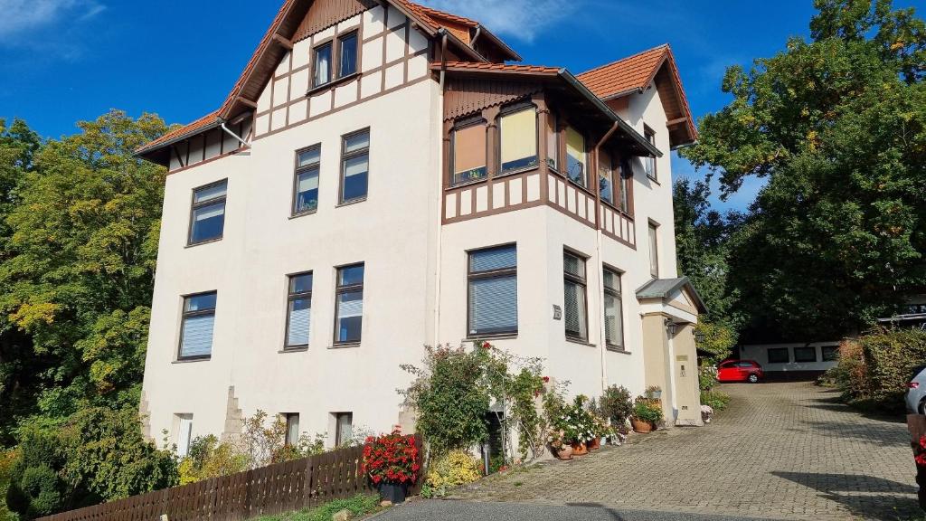 una casa blanca con techo de gambrel en Haus Sonneck, en Bad Sachsa
