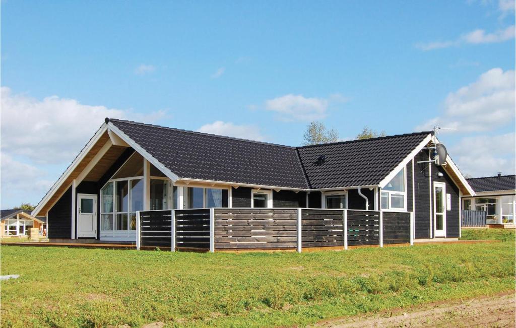 a house with a black roof on a green field at Beautiful Home In Nordborg With 3 Bedrooms, Sauna And Wifi in Nordborg