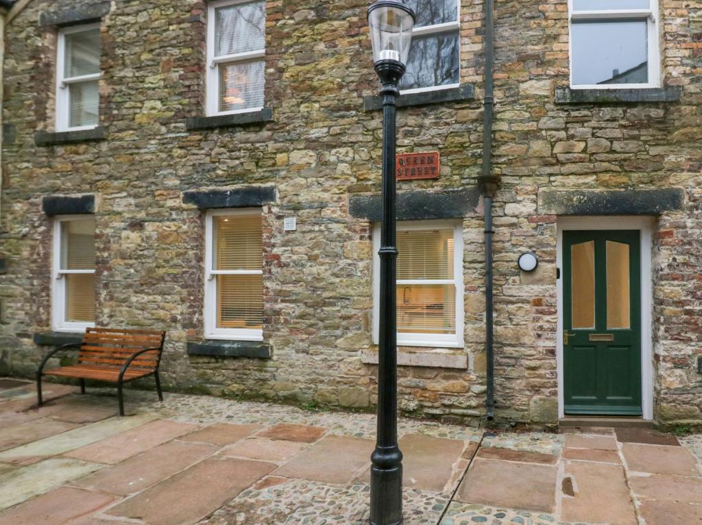 a street light in front of a building with a bench at Printers Cottage in Cockermouth