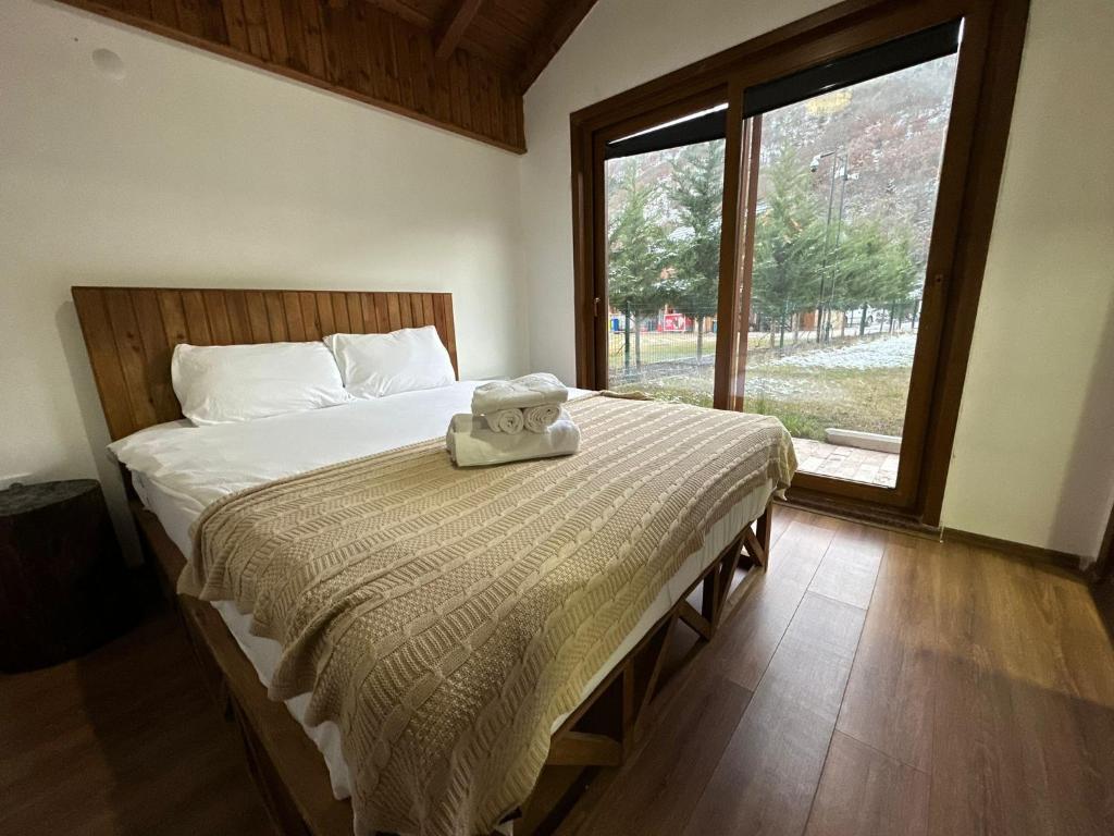 a bedroom with a bed with a teddy bear on it at Haremi Garden Suit Bungalows in Tokat