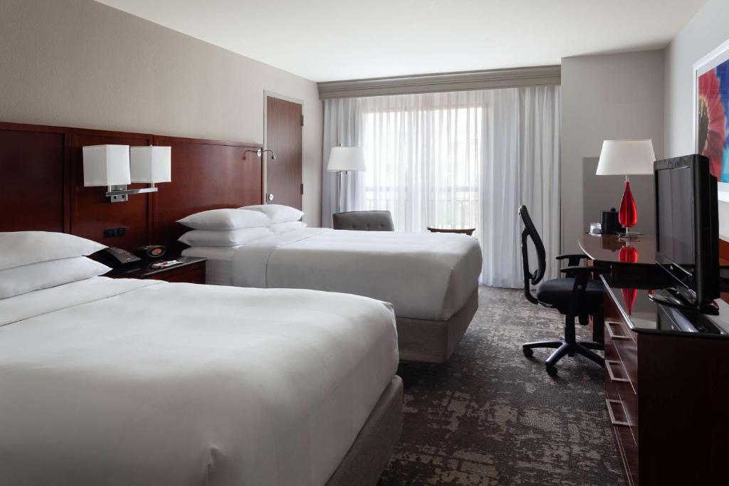 a hotel room with two beds and a desk at DoubleTree by Hilton Minneapolis Airport, MN in Bloomington