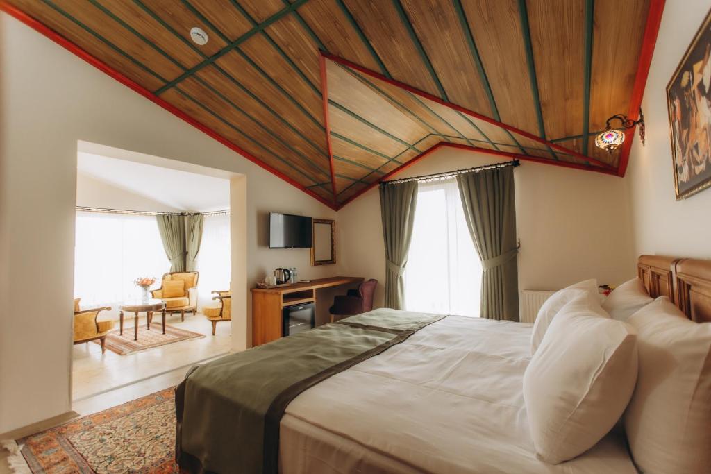 a bedroom with a large bed with a wooden ceiling at Cappadocia Villa Comfort in Nevsehir