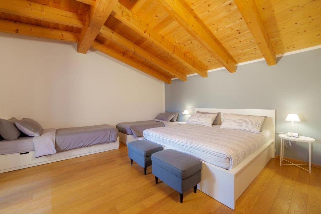 a bedroom with a bed and two stools at Bergamo bnb in Villa di Serio