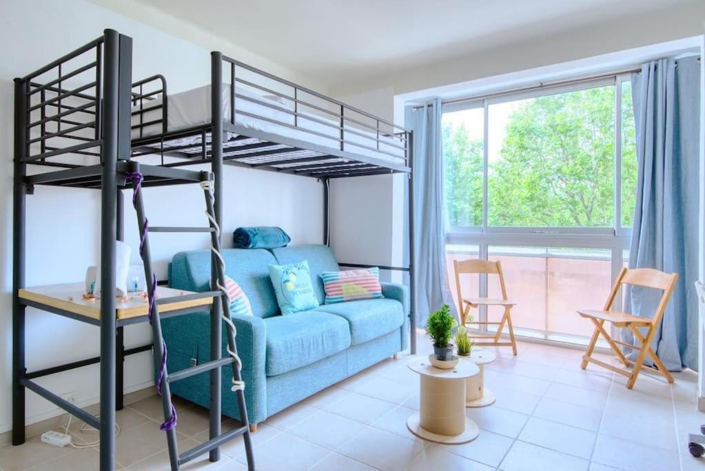 1 dormitorio con litera y sofá azul en BRONZET - T1 à 14 min à pied de la Plage de la Verrerie en Marsella
