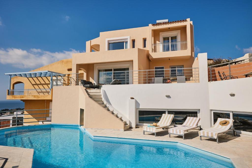 uma villa com piscina em frente a uma casa em Athens Riviera Villa em Anavissos