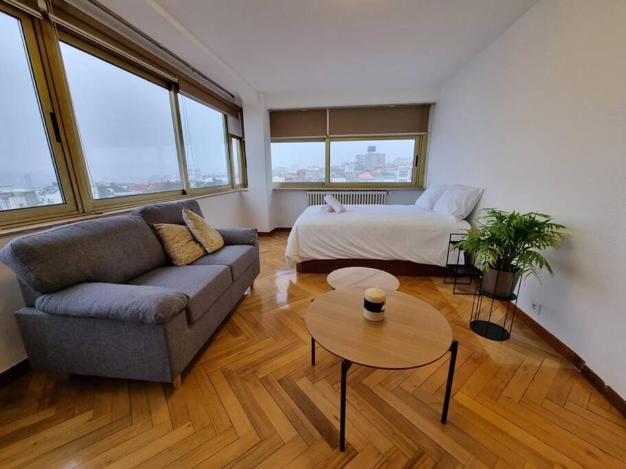 ein Wohnzimmer mit einem Sofa und einem Bett in der Unterkunft VibesCoruña- Ponte 2 in A Coruña