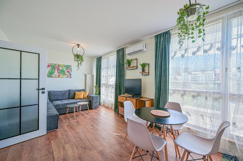 un soggiorno con tavolo, sedie e divano di Tropicana Penthouse – 1 Bedroom a Sofia