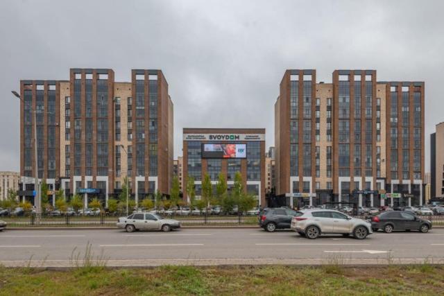 ein Parkplatz mit Autos vor hohen Gebäuden in der Unterkunft Брутальная квартира ЖK Sport Sity LUX in Astana