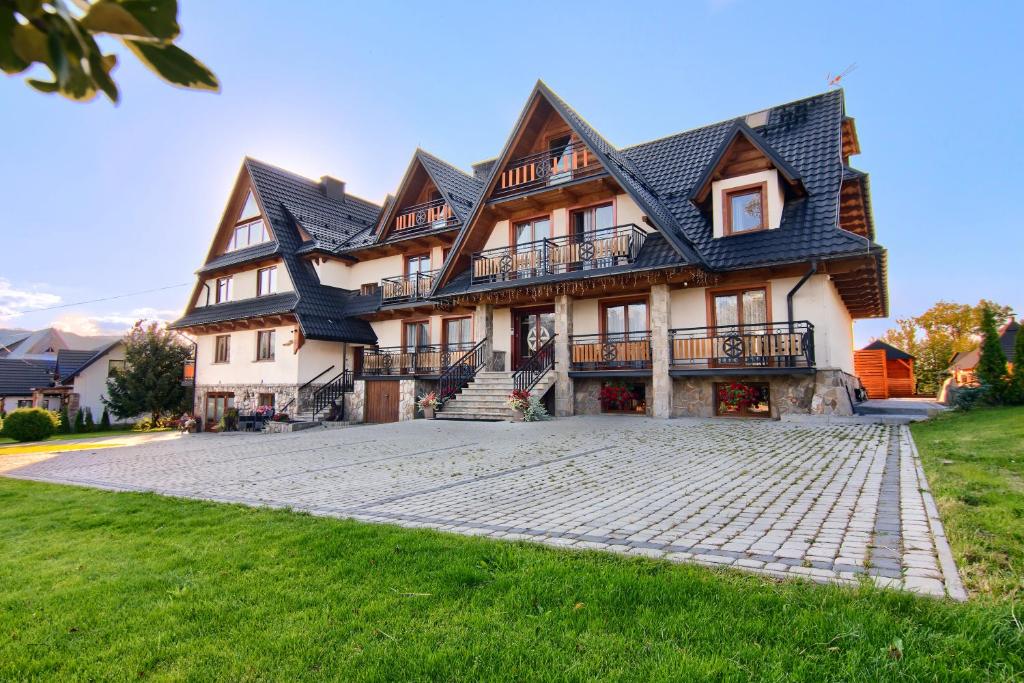 a large house with a stone driveway in front of it at Willa Królewska in Kościelisko