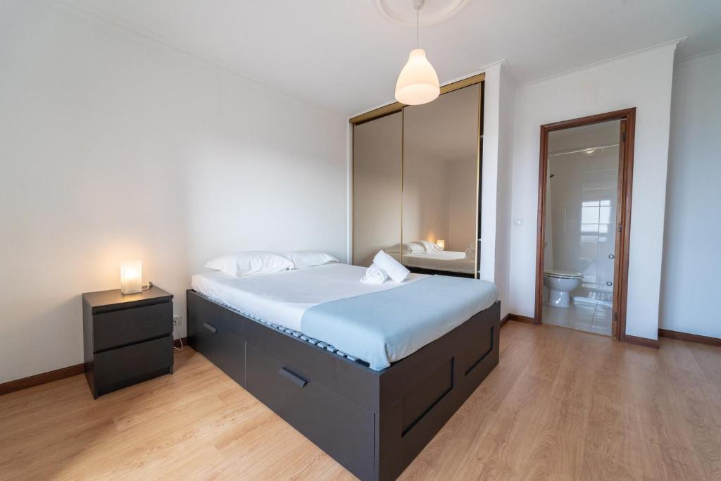 een slaapkamer met een groot bed en een badkamer bij Feliciano Ramos 1 - T4 familiar perto do centro da cidade - Braga in Braga