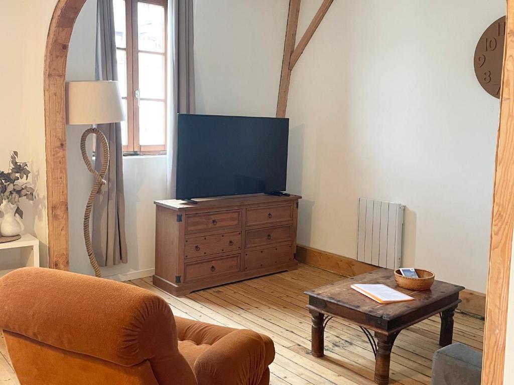 a living room with a television on a wooden dresser at Joli T4 au coeur de Berck-Plage in Berck-sur-Mer