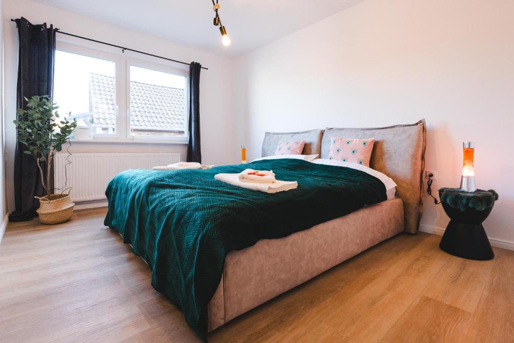um quarto com uma cama com um cobertor verde em Ferienwohnung für 4: WiFi, Küche, Netflix, Zentral em Bad Neuenahr-Ahrweiler