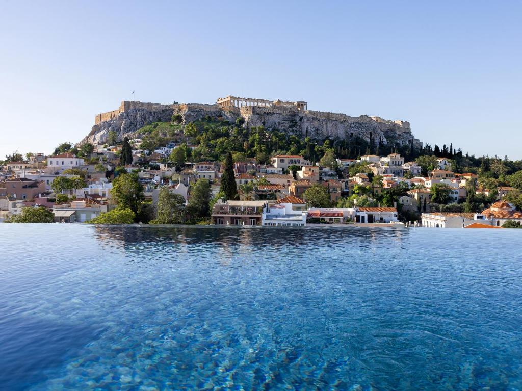 een grote hoeveelheid water met een stad op een heuvel bij The Dolli at Acropolis in Athene