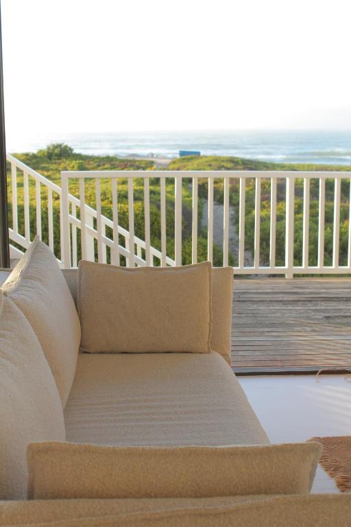 スティル・ベイにあるPlankeplekkieのソファ付きの海の景色を望むバルコニー