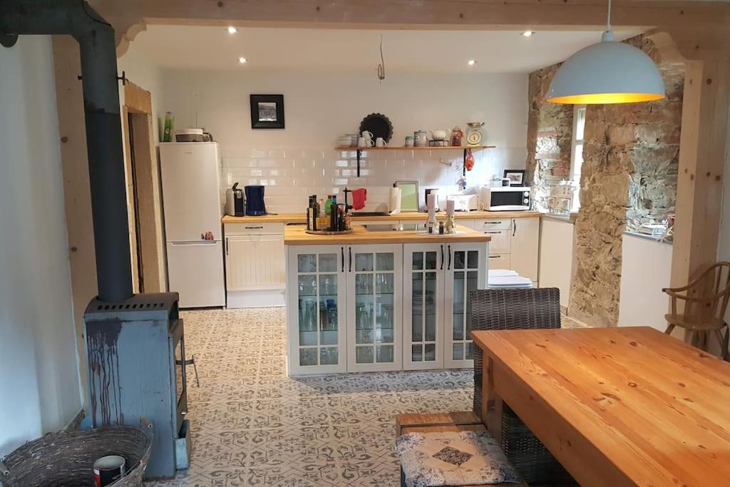 a kitchen with white cabinets and a table in it at Großes Charmantes Ferienhaus in Nassau in Frauenstein