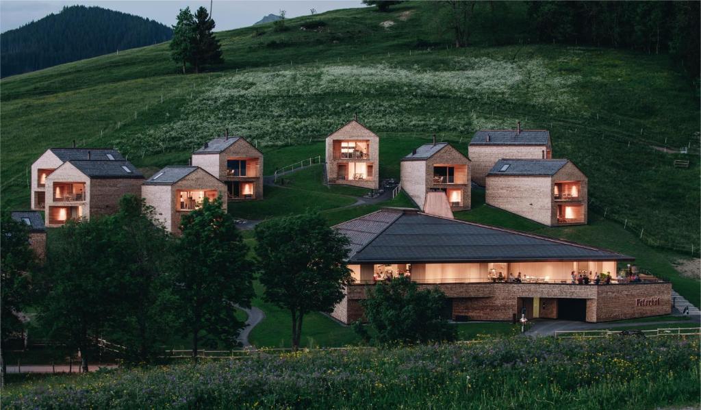 a large house on a hill with lights on at Peterhof Chalets in Batschuns