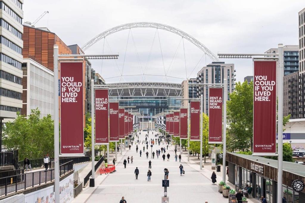 a street in a city with a stadium in the background at LiveStay Room with Free Parking in Wembley in London