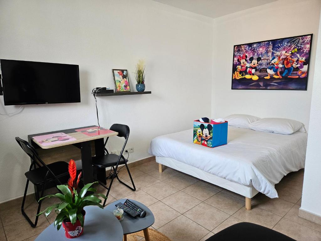 Habitación con cama, escritorio y TV. en Appartement Disneyland Paris Montevrain, en Montévrain