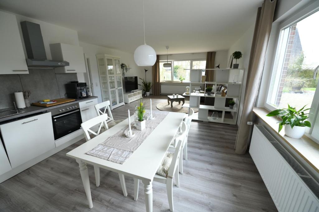een keuken en eetkamer met een witte tafel en stoelen bij Ferienwohnung Niestetal in Niestetal