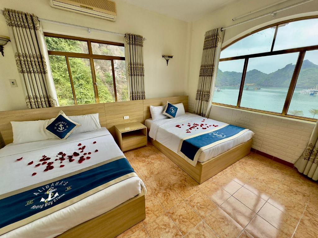 um quarto de hotel com duas camas e uma janela em Cat Ba Plaza hotel em Ilha de Cát Bà