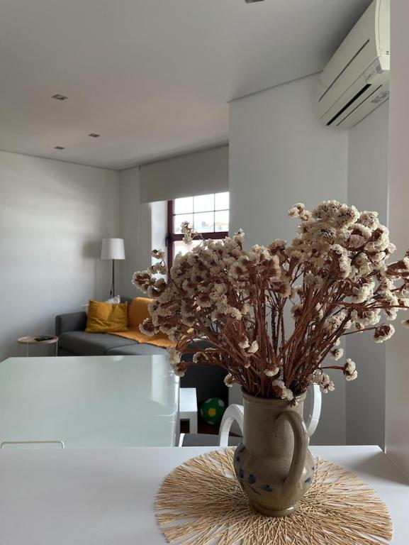 a vase with flowers on a table in a living room at Apartament Praceta Vila do Conde in Vila do Conde