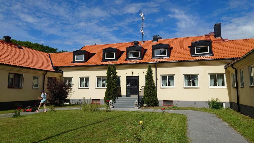 een groot wit gebouw met een oranje dak bij Ekängens Pensionat Garde in Ljugarn