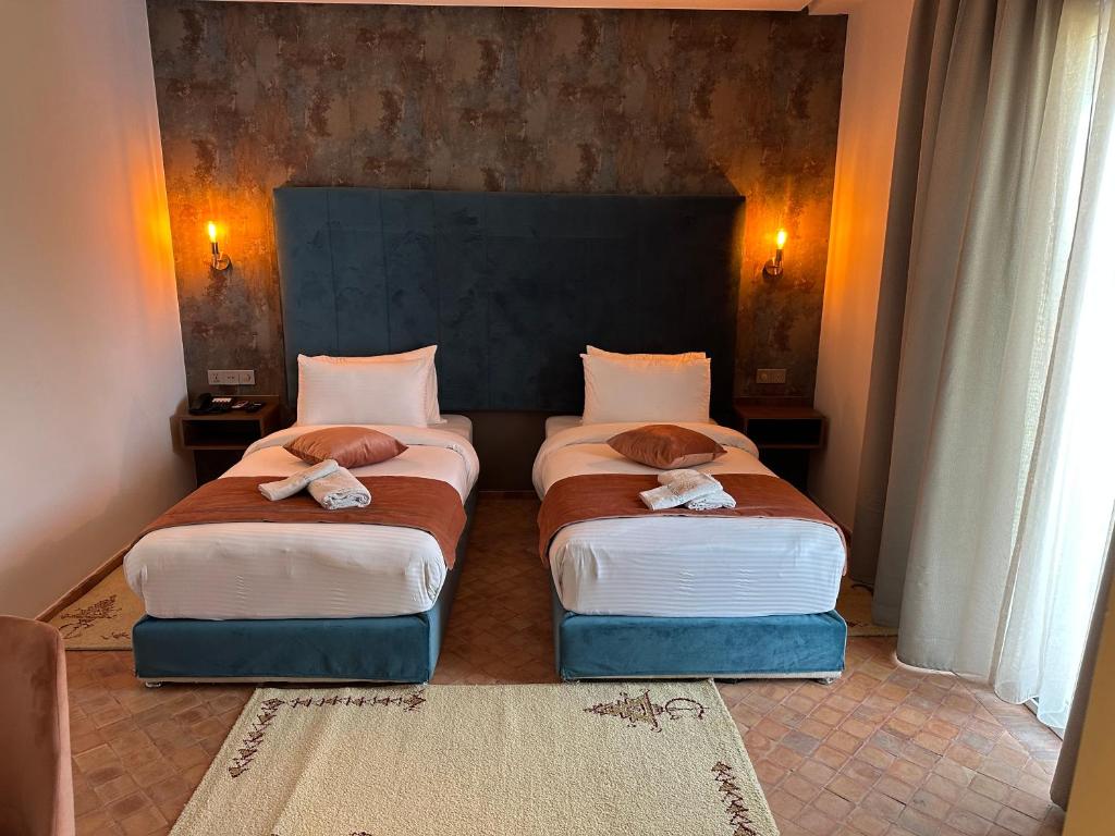 duas camas num quarto de hotel com toalhas em Dar Ba Sidi & Spa em Chefchaouene