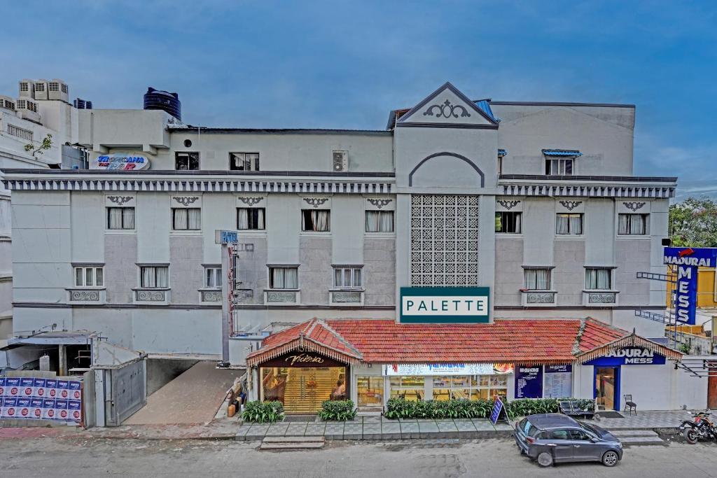 un gran edificio blanco con un mercado frente a él en OYO Palette - Hotel Victoria, en Chennai