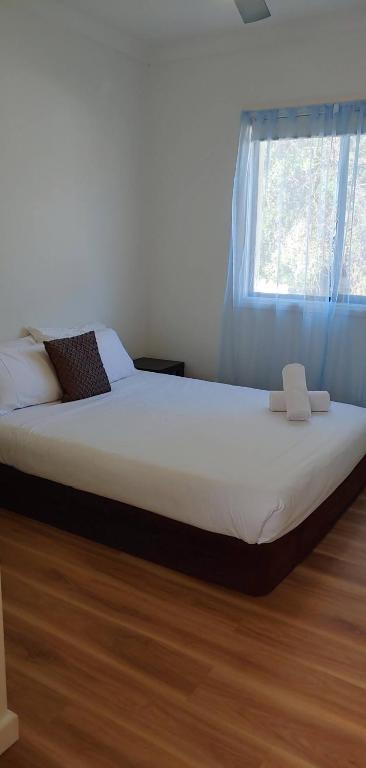 a bed sitting in a bedroom with a window at Great Three Bedroom House Opposite Hospital & University in Frankston