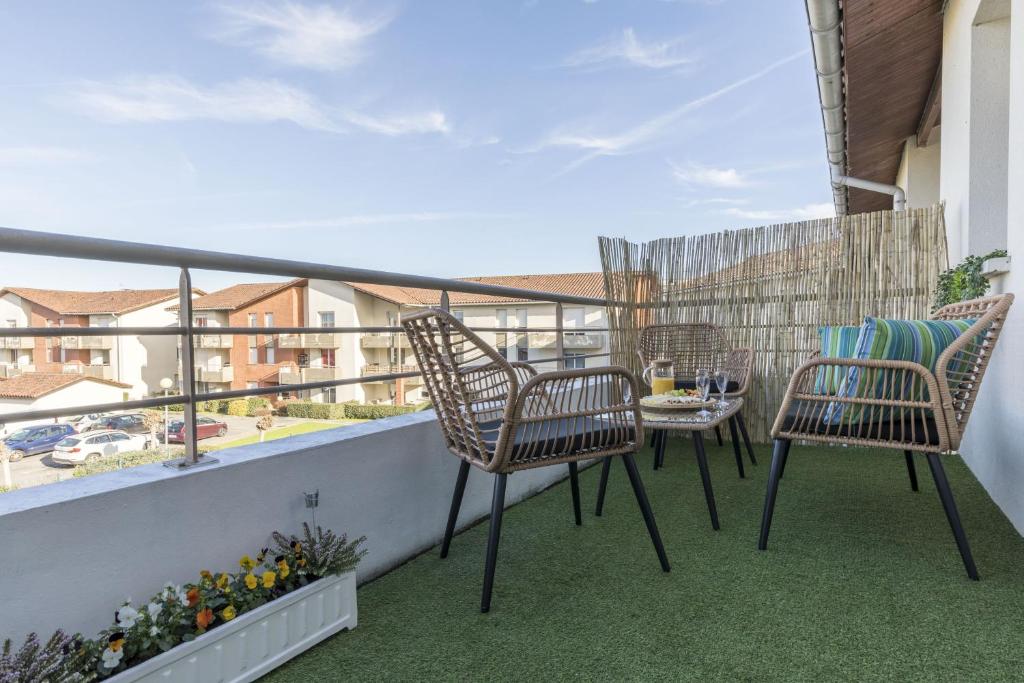 a patio with chairs and a table on a balcony at Spacieux proche aéroport et airbus in Toulouse
