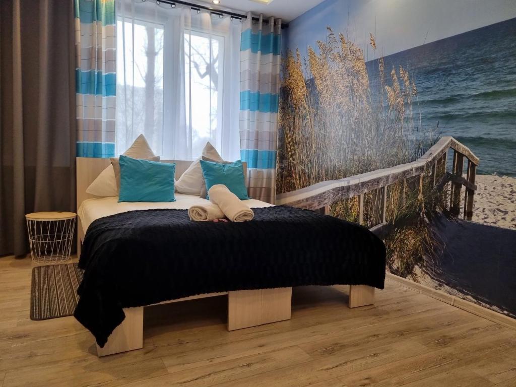 1 dormitorio con 1 cama y una pintura de playa en Zachodnia - 3 Pokoje, Manufaktura Parking, , FV en Lodz
