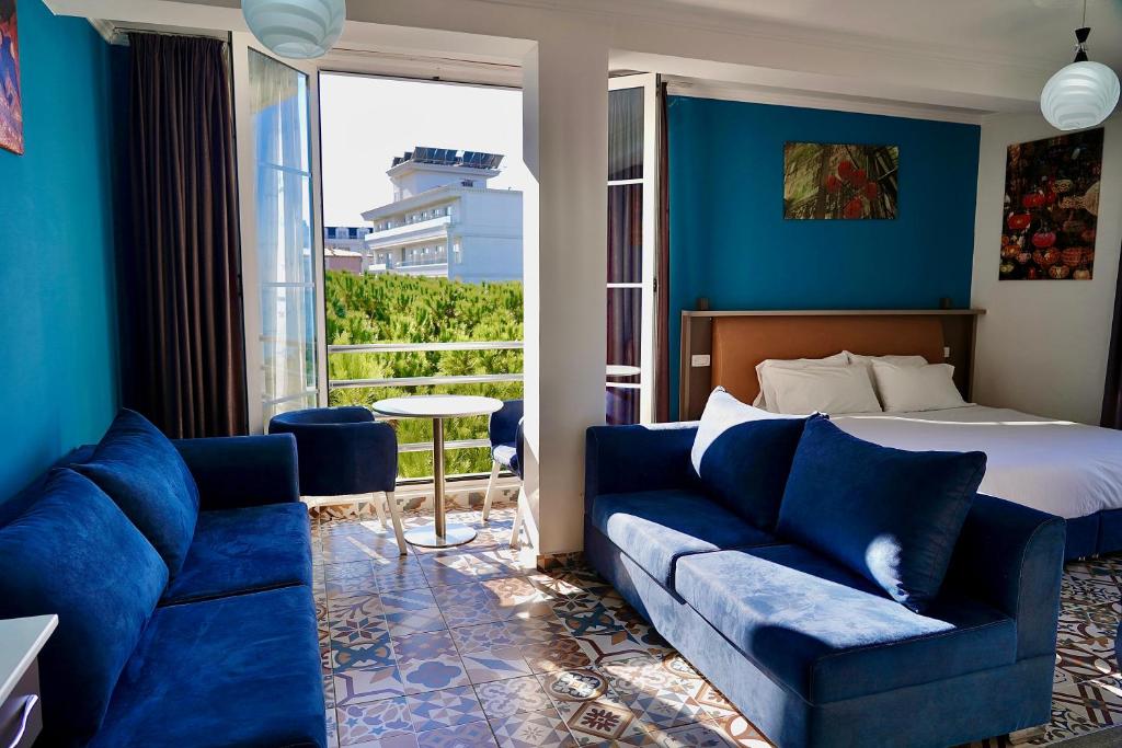 Habitación de hotel con cama y sofá en Hotel Monaco & Garden, en Golem