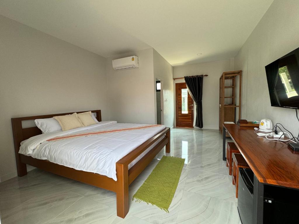 ein Schlafzimmer mit einem großen Bett und einem TV in der Unterkunft บ้านกานดา in Seka