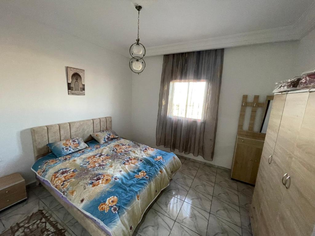 1 dormitorio con cama y ventana en DIaR MAHER en Al Maqārisah