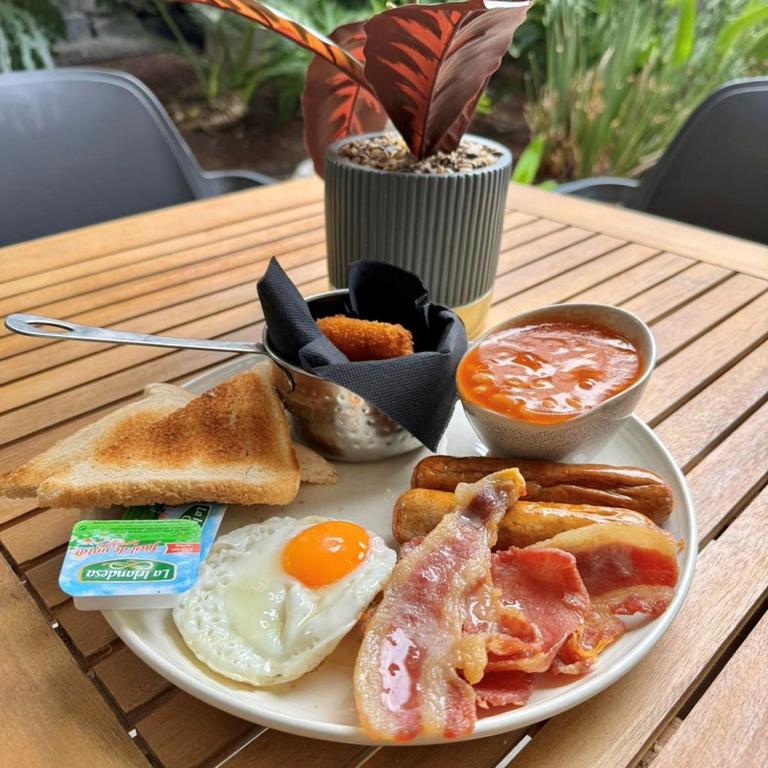 a plate of breakfast food with eggs bacon and toast at Holiday Club Puerto Calma in Puerto Rico de Gran Canaria