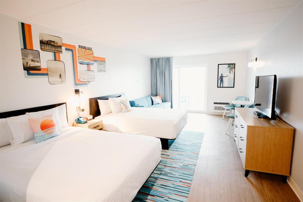 Habitación de hotel con 2 camas y TV de pantalla plana. en SeaLoft Oceanfront Hotel en Ocean City