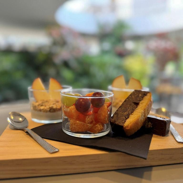 a wooden tray with a plate of food with desserts at Holiday Club Puerto Calma in Puerto Rico de Gran Canaria