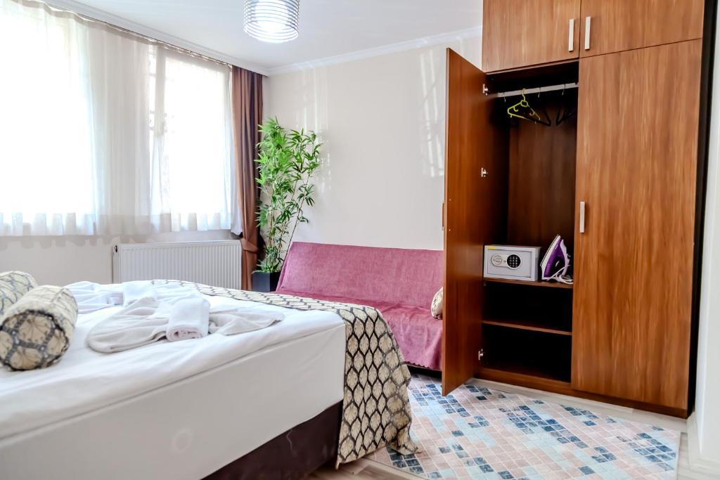 a hotel room with a bed and a cabinet at City Hall Apart Hotel Sultanahmet in Istanbul