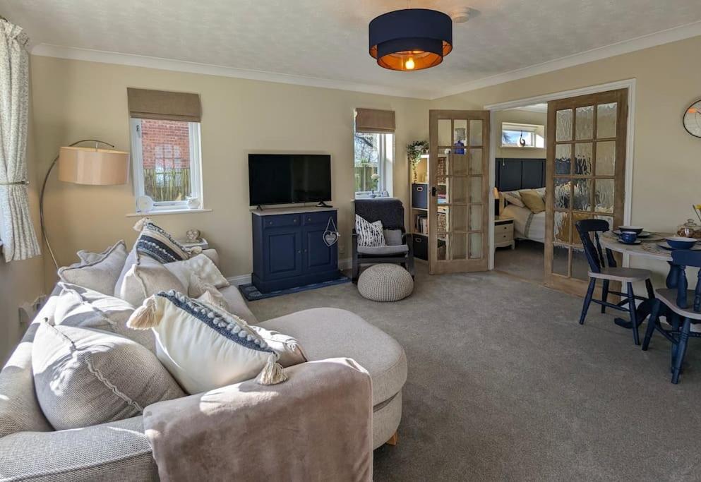 a living room with a couch and a table at Firs End - Close to Norfolk Broads and Coast - Crabpot Cottages Sheringham in North Walsham