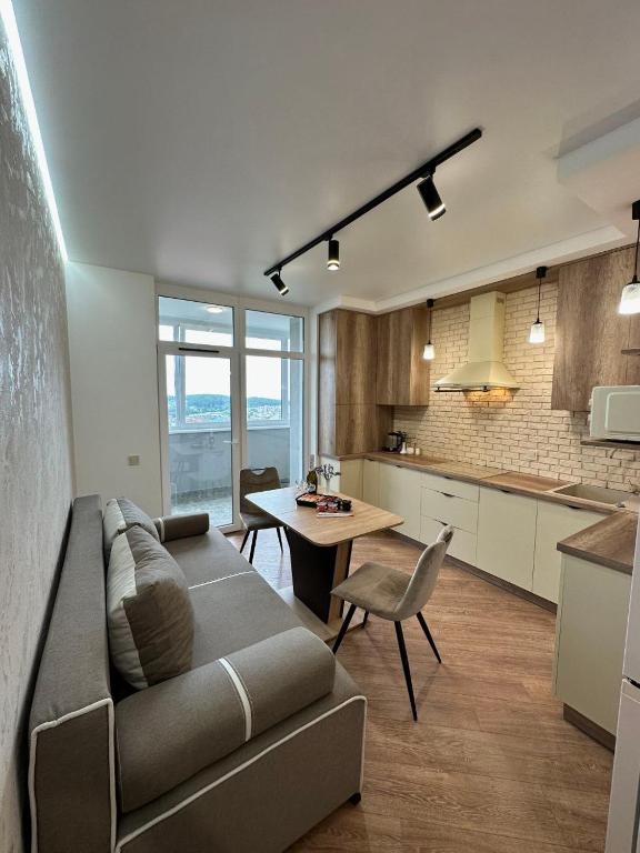 a living room with a couch and a table in a kitchen at Apartamenty Stepana Bandery 35 in Truskavets