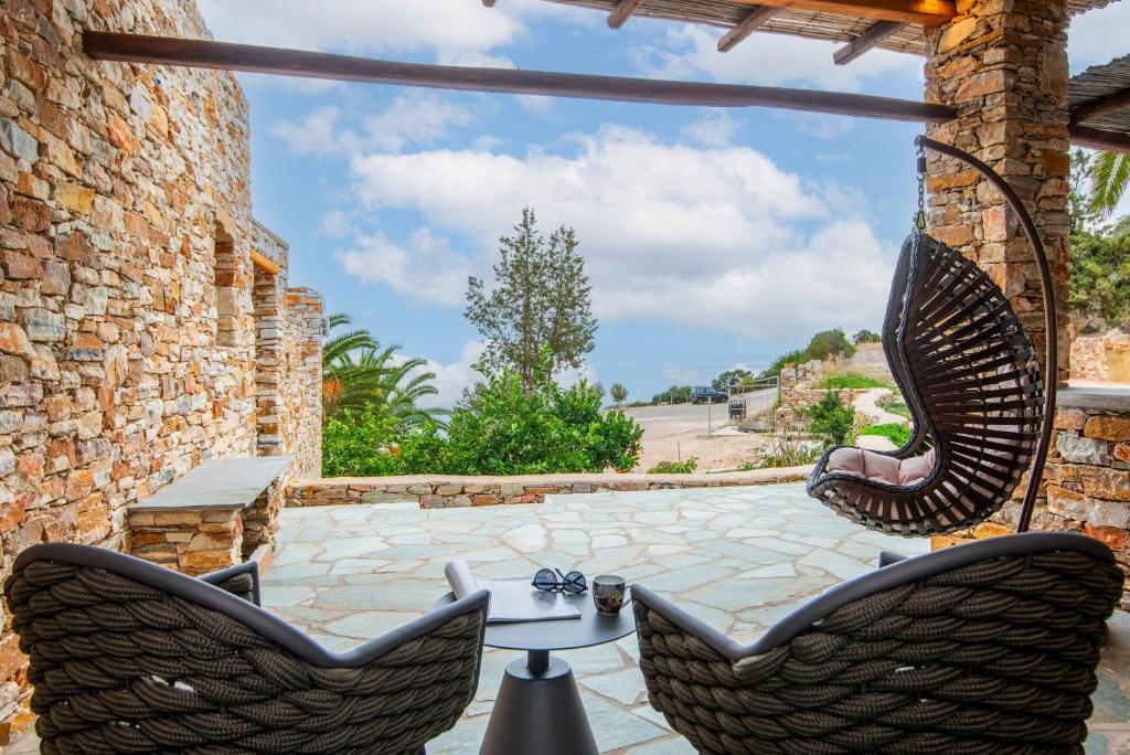 un patio con dos sillas y una mesa en White and black Suites Triple, en Sifnos