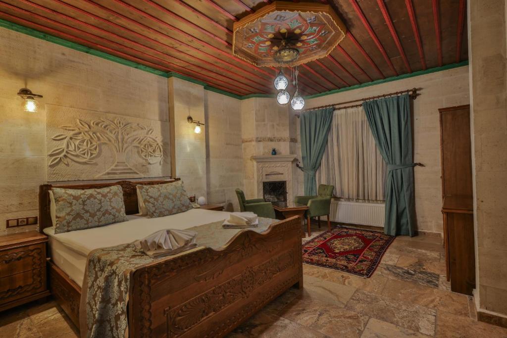a bedroom with a bed and a chandelier at Feel Cappadocia Stone House in Goreme