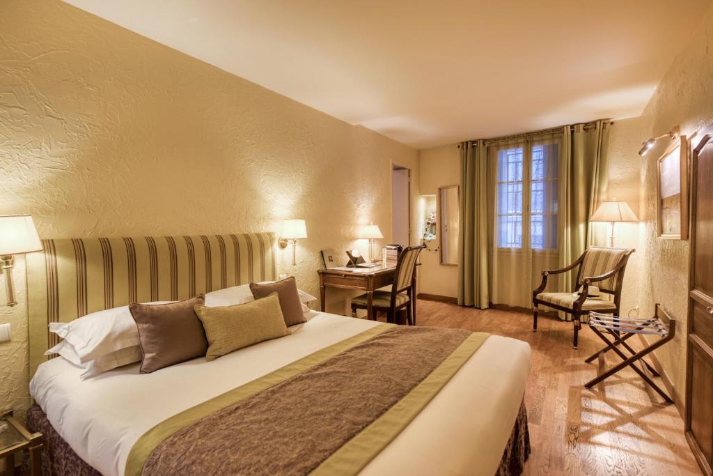 a hotel room with a bed and a desk at Hotel d'Aragon - Place de la Comédie in Montpellier