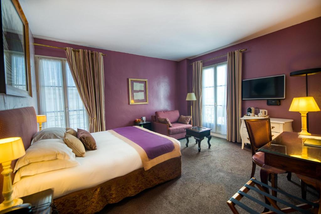 een hotelkamer met een groot bed en een stoel bij Hotel d'Aragon in Montpellier