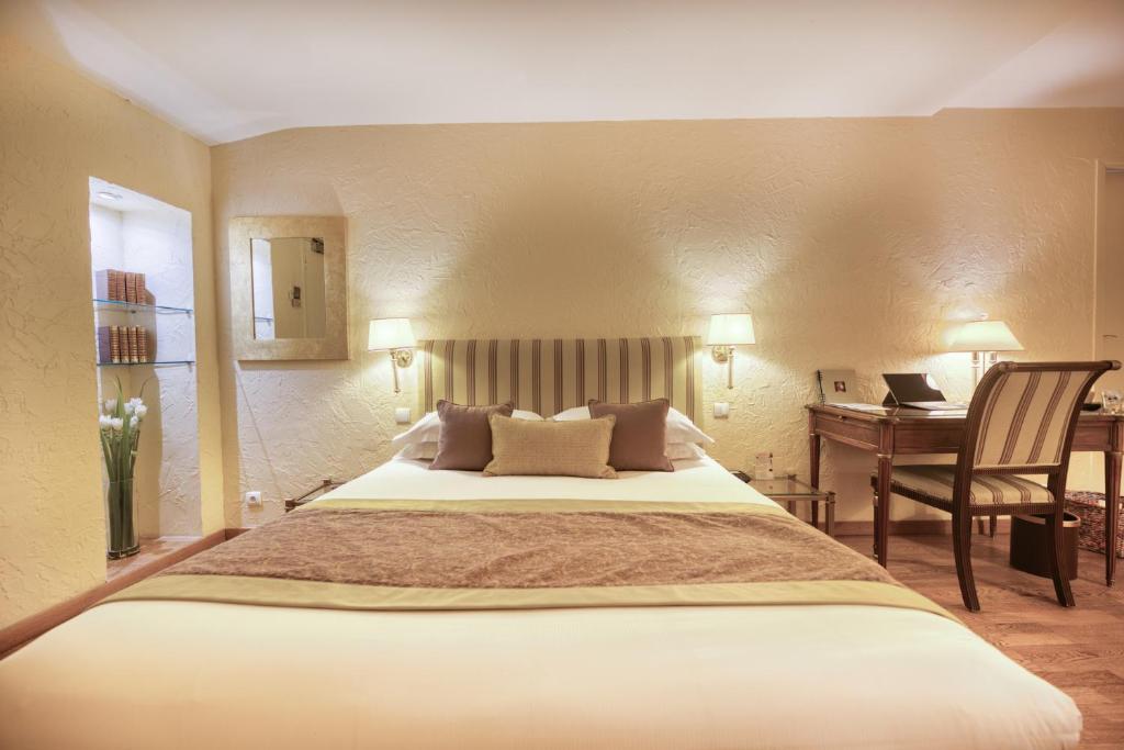 a bedroom with a large bed and a desk with a computer at Hotel d'Aragon - Place de la Comédie in Montpellier