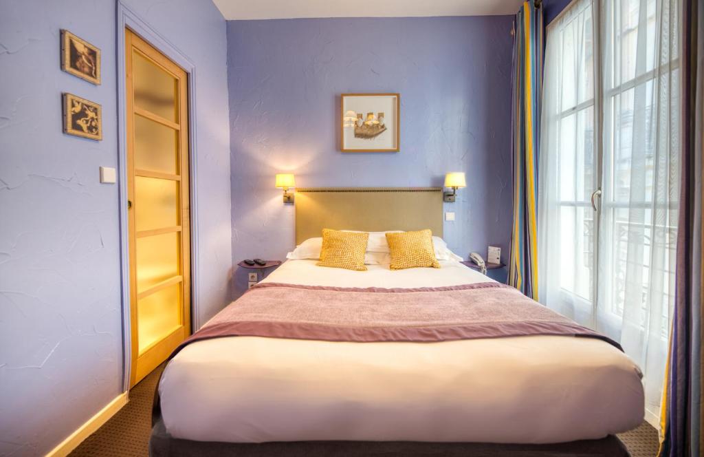 a bedroom with a large bed and a window at Hotel d'Aragon - Place de la Comédie in Montpellier