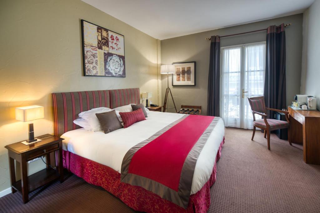 蒙佩利爾的住宿－阿拉貢酒店，酒店客房设有一张大床和一张书桌。