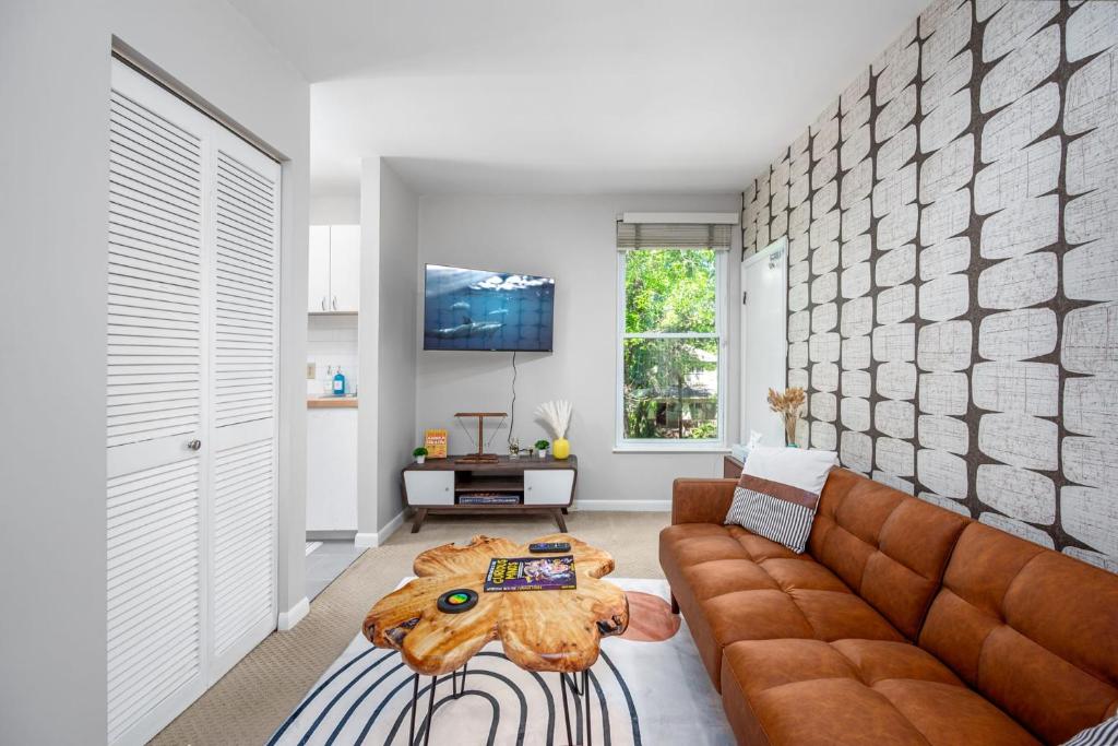 a living room with a brown couch and a table at Retro Loft steps from Duke in Durham