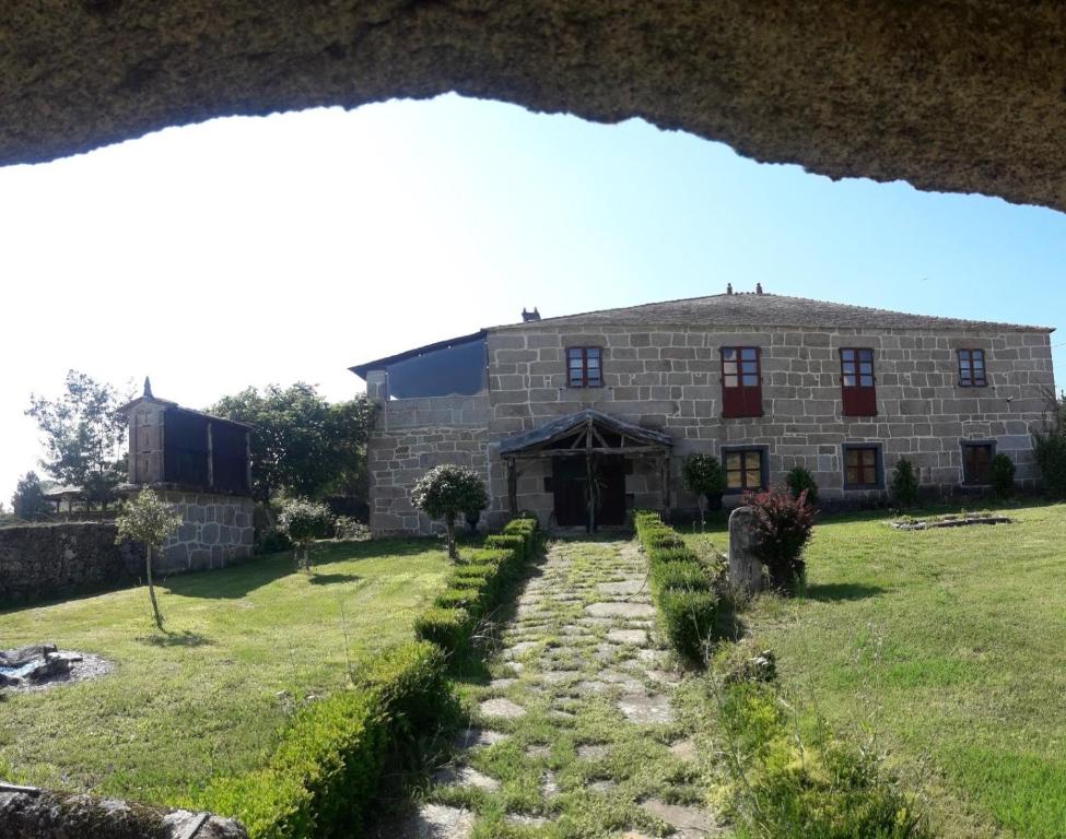 un antiguo edificio de piedra con un camino que conduce a él en Casa Rural del General Albelda, en Villasante